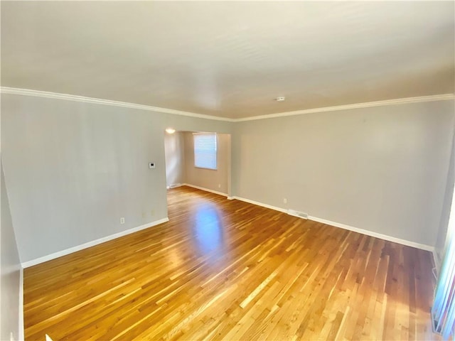 empty room with crown molding and hardwood / wood-style flooring