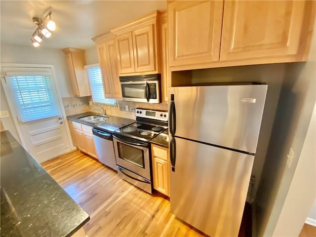 kitchen with appliances with stainless steel finishes, sink, light wood-type flooring, and light brown cabinets