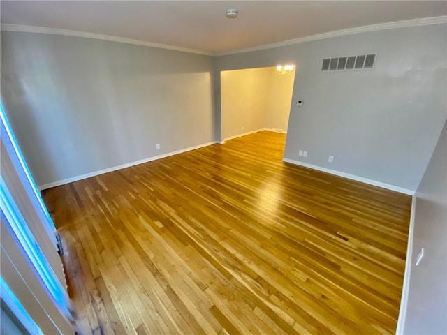 empty room with hardwood / wood-style flooring and ornamental molding