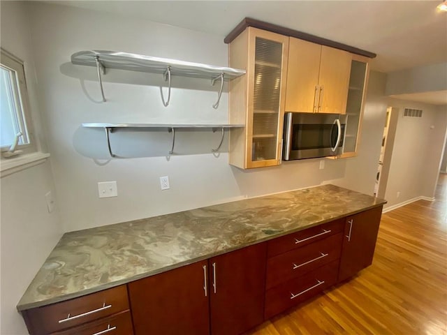 kitchen featuring light stone counters and light wood-type flooring