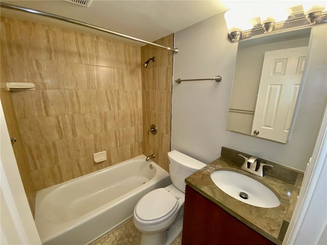 full bathroom featuring vanity, tiled shower / bath, and toilet