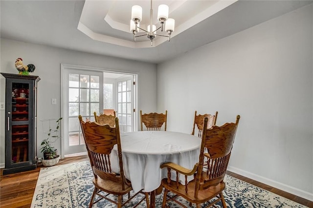 403 S Jackson St, Archie, MO 64725 - dining space with wood finished floors, a chandelier, and a tray ceiling