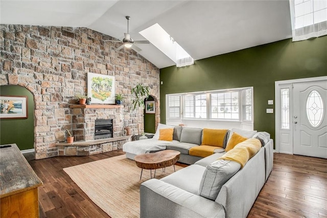 403 S Jackson St, Archie, MO 64725 - living area featuring ceiling fan, a skylight, high vaulted ceiling, a stone fireplace, and hardwood / wood-style floors
