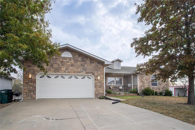 403 S Jackson St, Archie, MO 64725 - view of front facade with stone siding, driveway, an attached garage, and a front yard