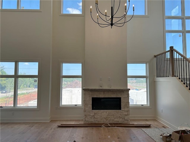 2846 W 133rd Ter, Leawood, KS 66209 - unfurnished living room with a chandelier, a towering ceiling, baseboards, wood finished floors, and stairway