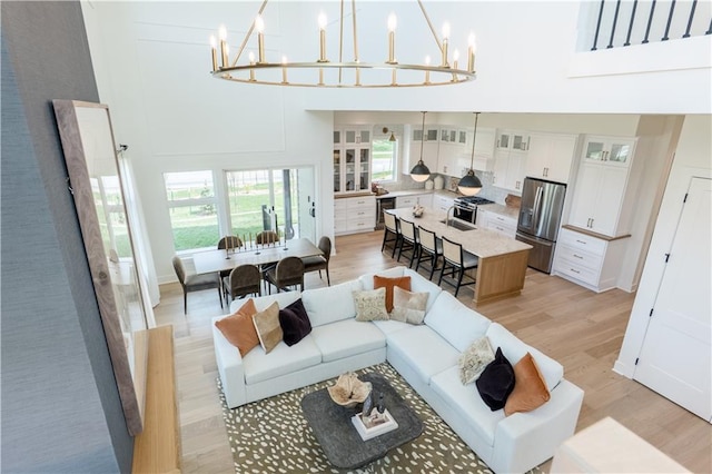 2846 W 133rd Ter, Leawood, KS 66209 - living room with a high ceiling, a chandelier, and light wood finished floors