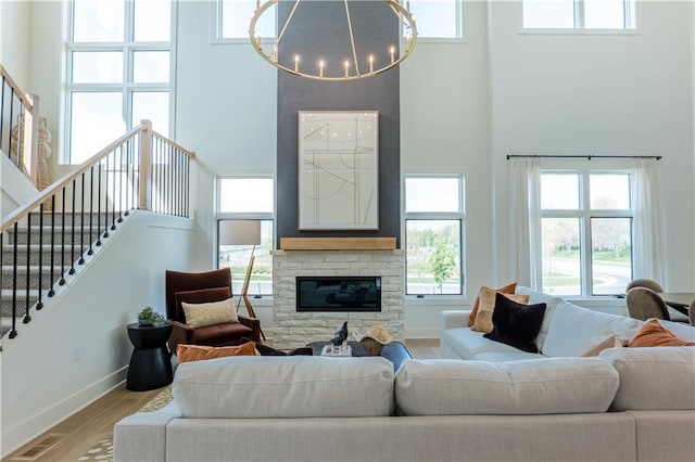 2846 W 133rd Ter, Leawood, KS 66209 - living area with a high ceiling, a chandelier, wood finished floors, baseboards, and a stone fireplace