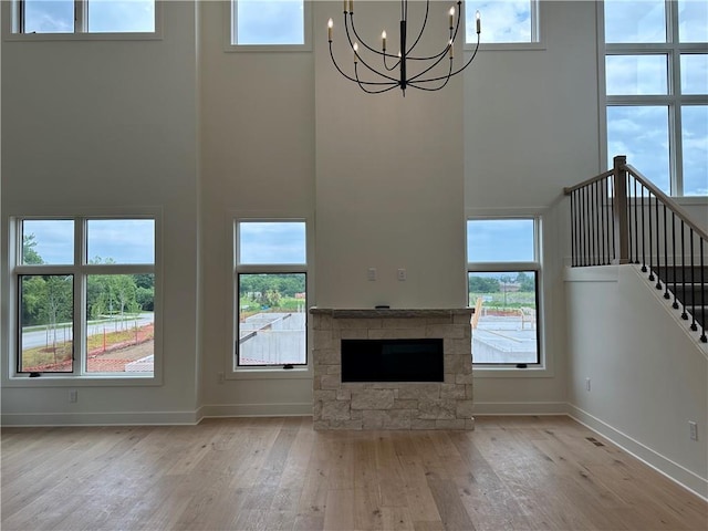 2846 W 133rd Ter, Leawood, KS 66209 - unfurnished living room featuring a towering ceiling, a chandelier, wood-type flooring, and healthy amount of natural light