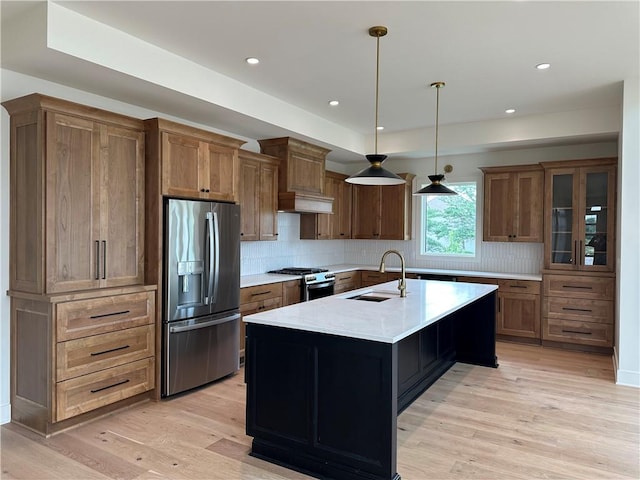 2846 W 133rd Ter, Leawood, KS 66209 - kitchen with stainless steel appliances, backsplash, light wood finished floors, a kitchen island with sink, and pendant lighting
