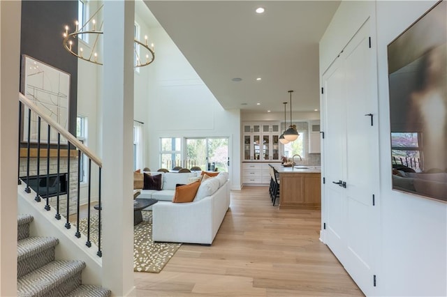 2846 W 133rd Ter, Leawood, KS 66209 - living area with light wood-style floors, stairs, recessed lighting, a chandelier, and a towering ceiling
