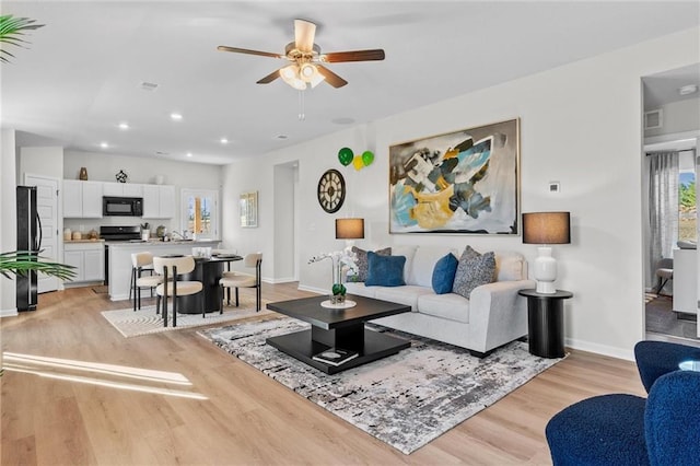 living room with ceiling fan and light wood-type flooring