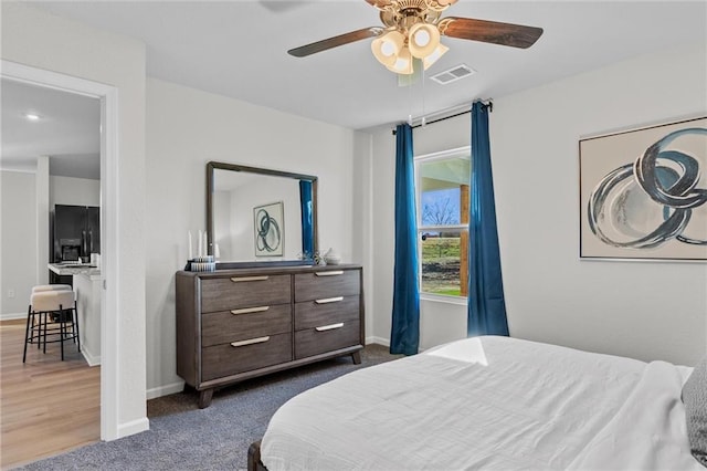 bedroom featuring ceiling fan, dark hardwood / wood-style flooring, and black refrigerator with ice dispenser