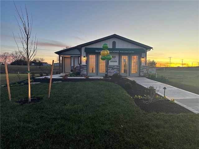 view of front of house featuring french doors and a lawn