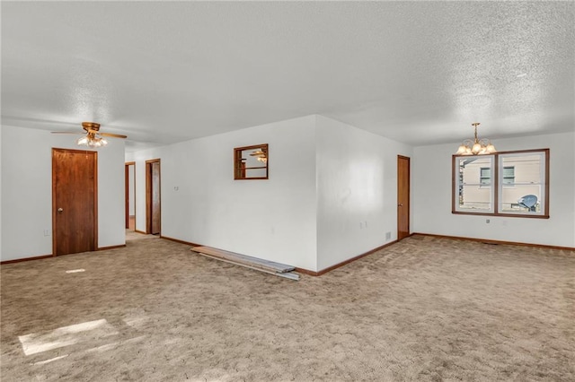 spare room featuring a textured ceiling, carpet floors, and ceiling fan with notable chandelier