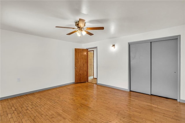 unfurnished bedroom featuring light hardwood / wood-style flooring, a closet, and ceiling fan