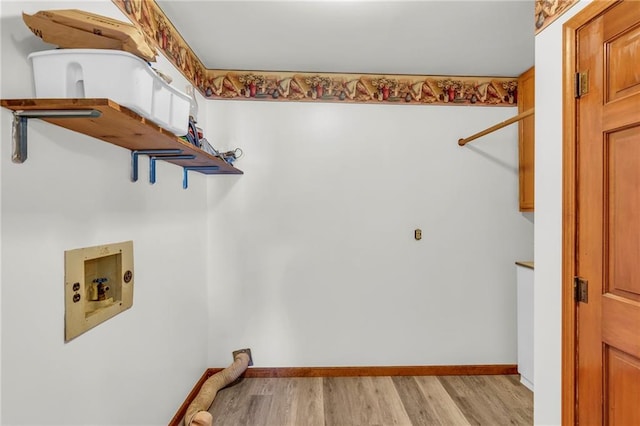 clothes washing area featuring hookup for a washing machine, light hardwood / wood-style floors, and cabinets