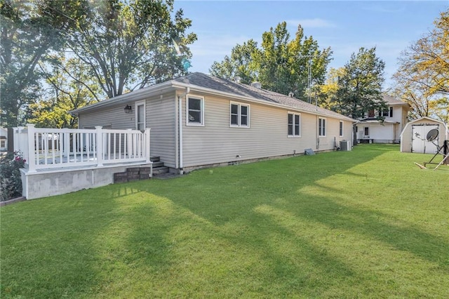 back of house with a wooden deck, central AC, a shed, and a lawn