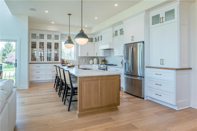 2860 W 133rd Ter, Leawood, KS 66209 - kitchen with light wood finished floors, backsplash, a sink, a kitchen bar, and appliances with stainless steel finishes