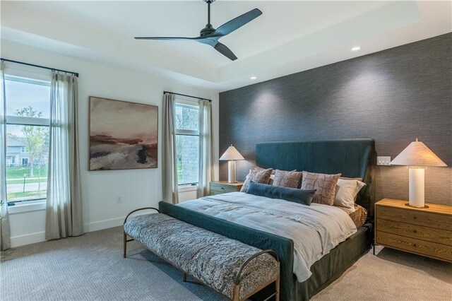 2860 W 133rd Ter, Leawood, KS 66209 - bedroom with baseboards, a tray ceiling, multiple windows, and light carpet