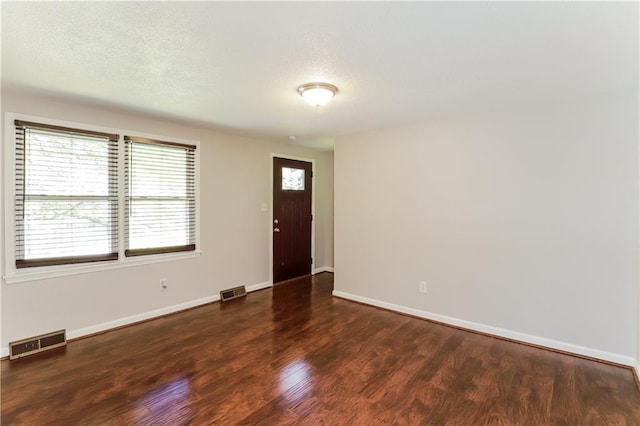 foyer entrance featuring dark wood-type flooring and a textured ceiling