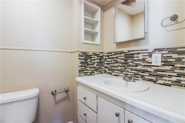 bathroom featuring vanity, toilet, and decorative backsplash