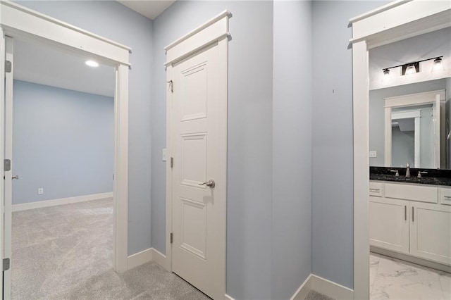 hallway with light carpet and sink