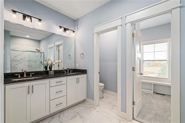 bathroom with toilet, a shower with door, and vanity