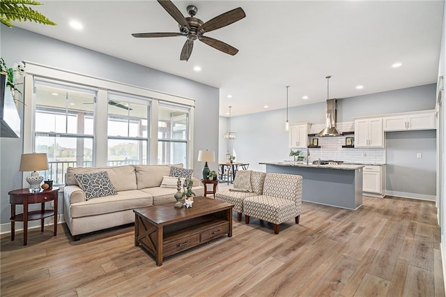 living room with ceiling fan and light hardwood / wood-style floors