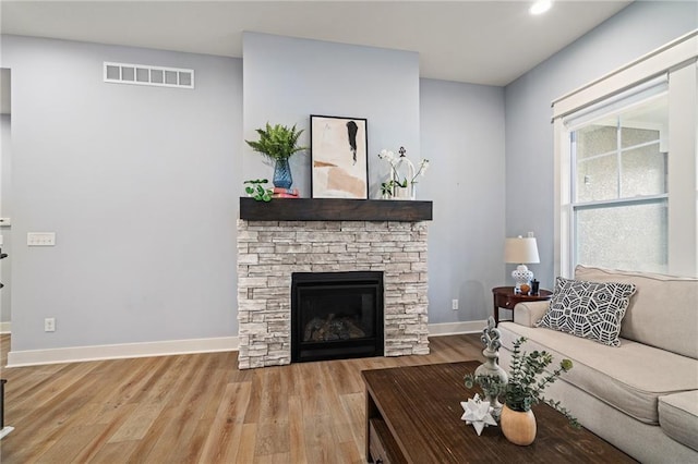 living room with light hardwood / wood-style floors and a fireplace