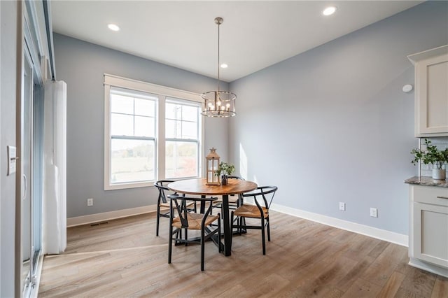 dining room featuring light hardwood / wood-style flooring and a chandelier