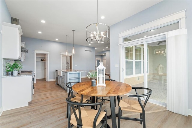 dining space with an inviting chandelier and light wood-type flooring