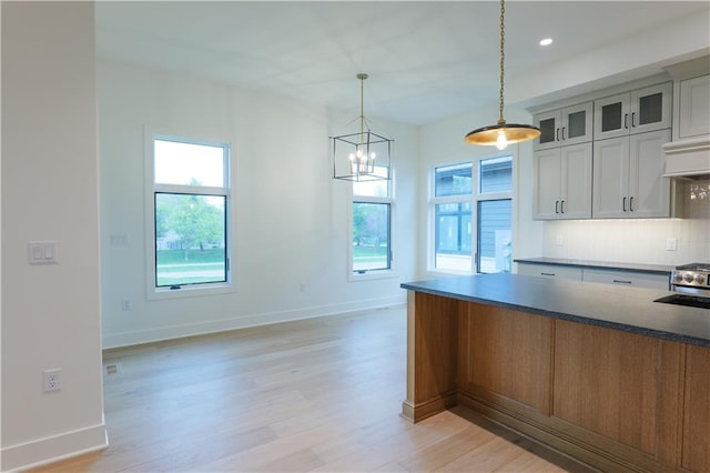 2852 W 133rd Ter, Leawood, KS 66209 - kitchen featuring light wood-style floors, baseboards, hanging light fixtures, glass insert cabinets, and recessed lighting