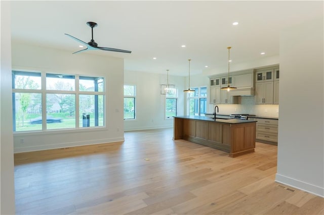 2852 W 133rd Ter, Leawood, KS 66209 - kitchen featuring light wood-style flooring, an island with sink, a ceiling fan, recessed lighting, and baseboards