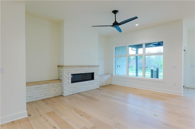 2852 W 133rd Ter, Leawood, KS 66209 - unfurnished living room featuring wood finished floors, a stone fireplace, a ceiling fan, baseboards, and recessed lighting