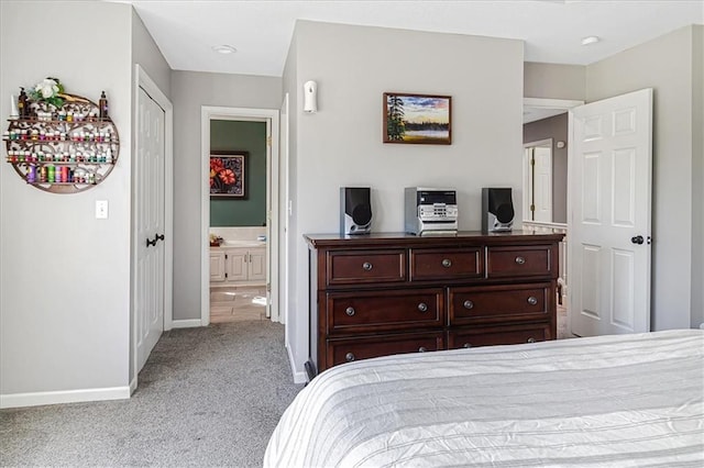 bedroom featuring light carpet and connected bathroom