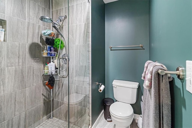 bathroom with a shower with door and toilet