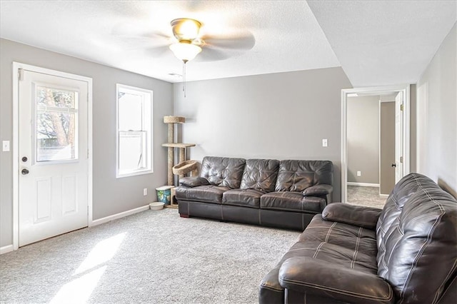 carpeted living room with ceiling fan and a textured ceiling