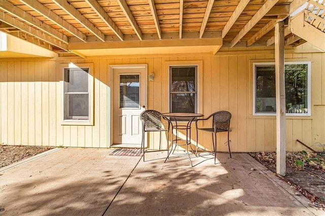 view of exterior entry with a patio area