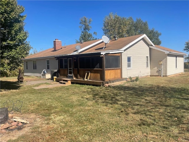 back of property featuring a sunroom and a lawn