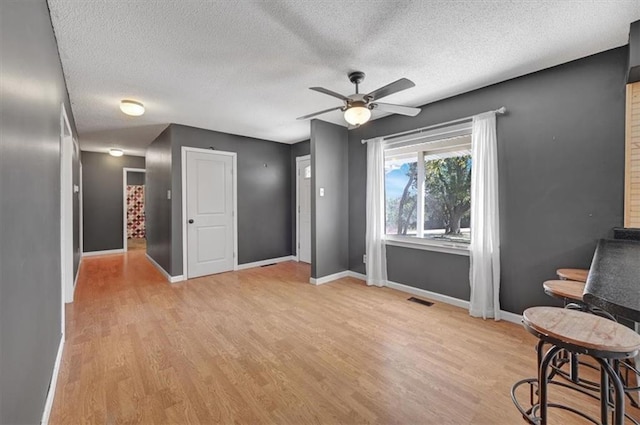 interior space featuring light hardwood / wood-style floors, a textured ceiling, and ceiling fan