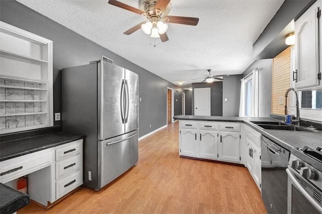 kitchen with sink, appliances with stainless steel finishes, kitchen peninsula, and white cabinets