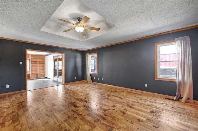 unfurnished room with ceiling fan, a textured ceiling, light hardwood / wood-style flooring, and ornamental molding