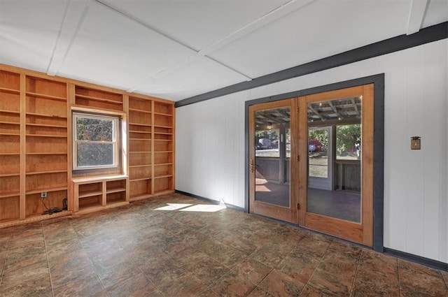 spare room with wooden walls and built in shelves