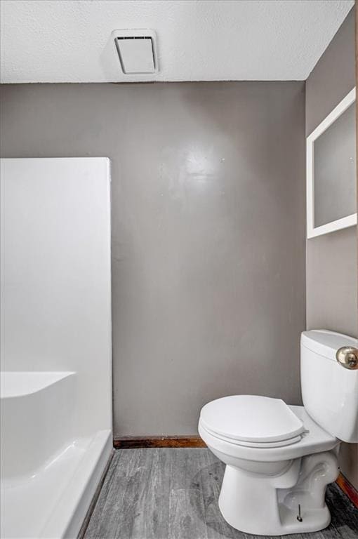 bathroom with toilet and wood-type flooring