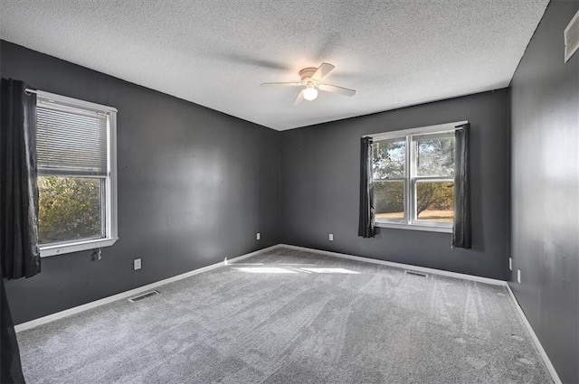 spare room with ceiling fan, carpet flooring, and a textured ceiling