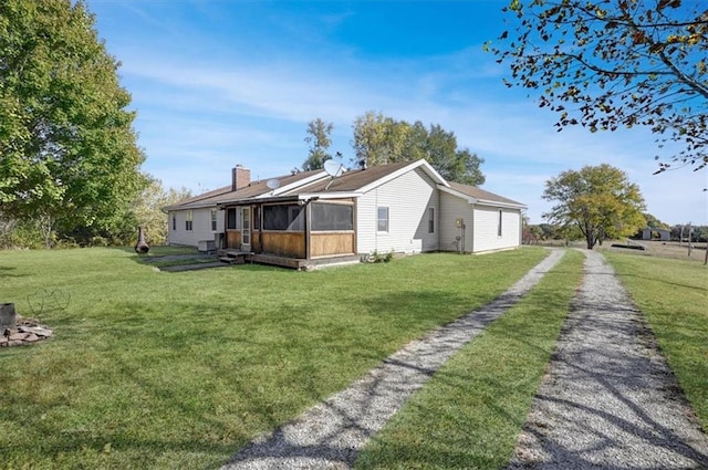 view of property exterior with a yard and a sunroom