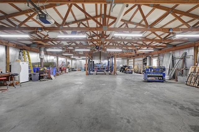 garage featuring white fridge and a garage door opener