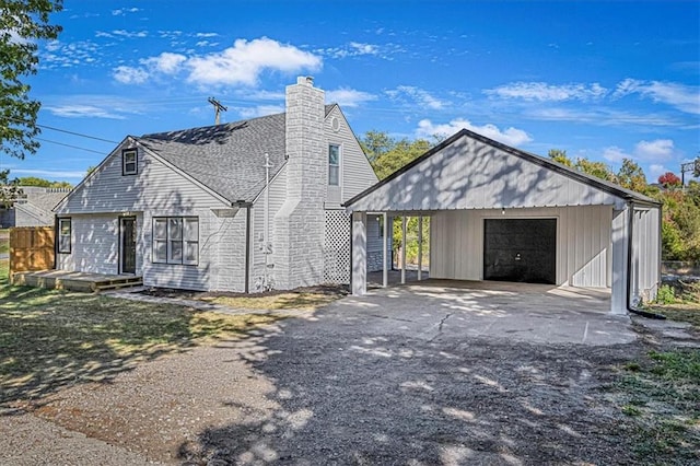 view of front facade featuring a garage and an outbuilding