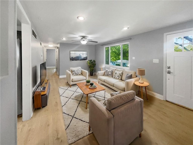 living room with light hardwood / wood-style floors and ceiling fan