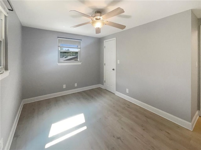 empty room with hardwood / wood-style floors and ceiling fan